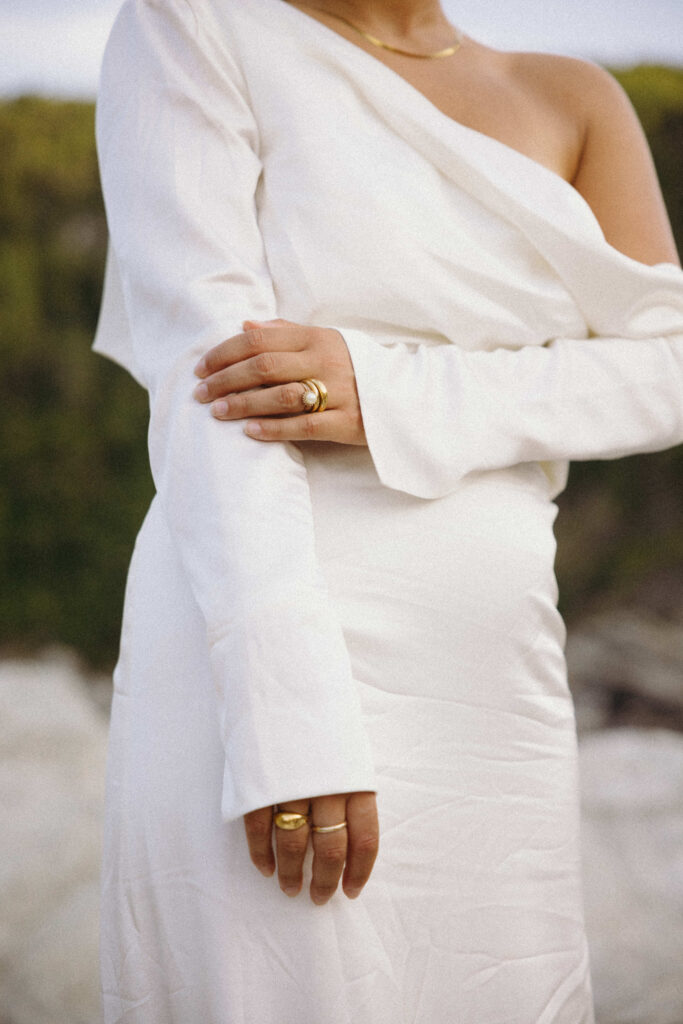 Bride wearing a Grace Loves Lace wedding dress at her Greece Elopement. Close up of Brides pearl and gold engagement ring and wedding band.